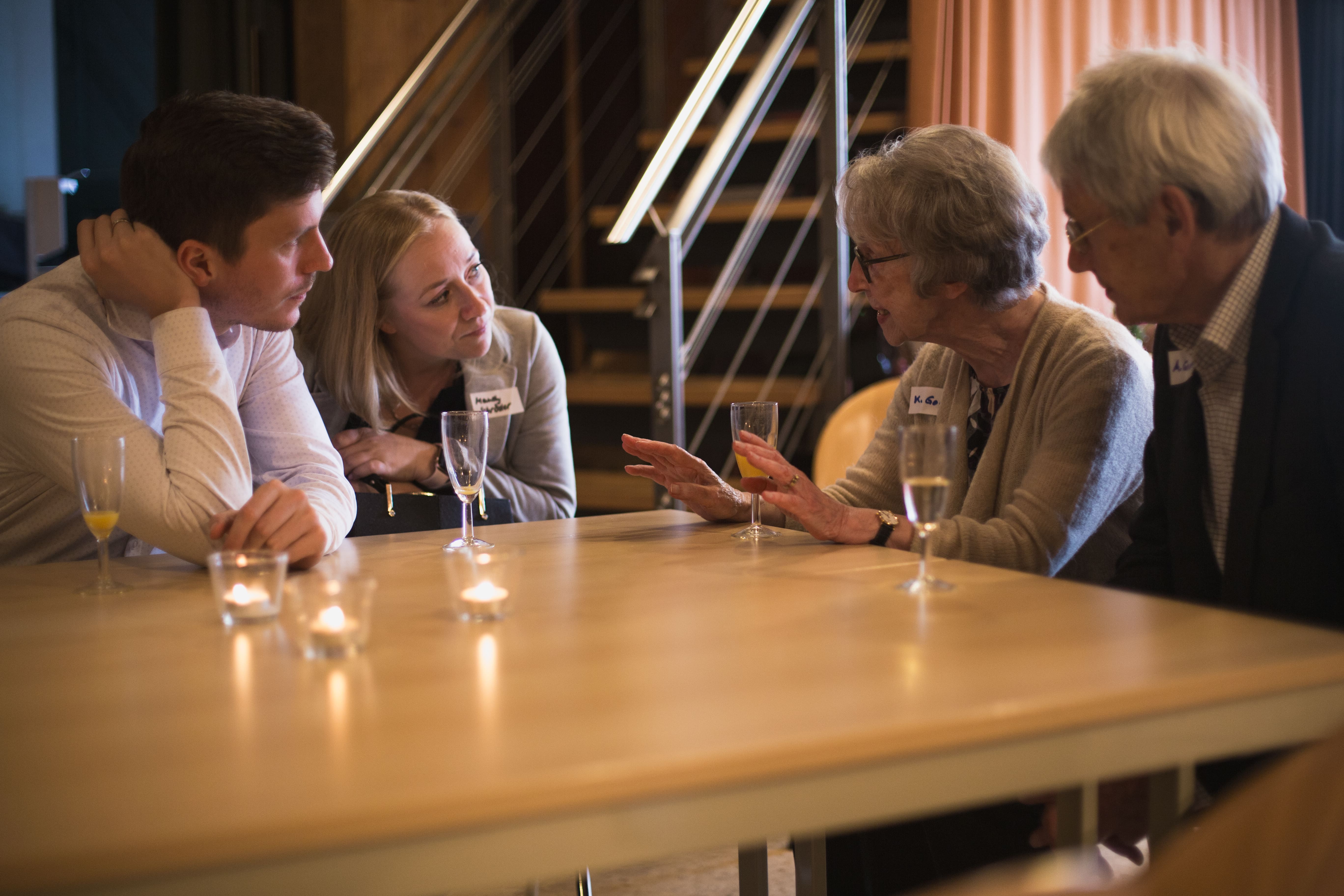 Unsere HASPA-Unterstützer:innen Nicolaj Kramer und Mandy Schröder und Spender:innen Karin und Albrecht Goerth sitzen an einem Tisch und sind tief im Gespräch. 