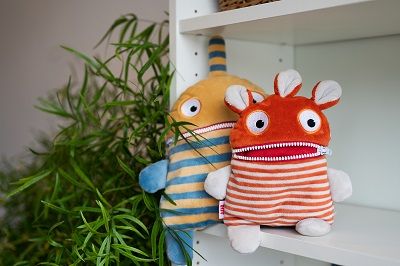 Zwei Sorgenfresser-Kuscheltiere auf einem Regalbrett